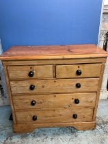 Victorian waxed pine chest of two short and three long drawers with turned ebonised handles on