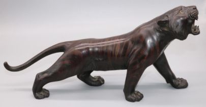 Japanese Meiji period patinated bronze model of a prowling tiger, with glass eyes and open mouth,