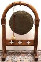Victorian brass circular dinner gong, in Gothic faceted and pierced oak arched top trestle frame,