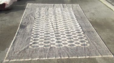 Bokhara pattern beige ground rug, field filled with stylized elephants foot medallions and stars