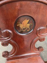 Set of four Victorian mahogany hall chairs, waisted scroll carved backs painted in roundel with