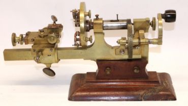 Victorian brass hand operated watchmakers' mandrel lathe, mounted on mahogany base together with