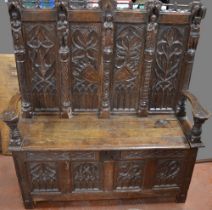 C17th and later oak box settle, raised back with pierced top rail, four gothic tracery carved panels