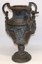 Large Victorian cast metal urn shaped two handled vase, decorated with a cherub, on circular base,
