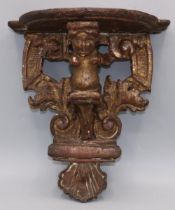 C19th carved oak giltwood wall bracket, shaped top on cherub, pierced scroll and shell support,