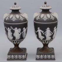 Pair of Wedgwood black jasperware urns and covers decorated with The Dancing Hours, twin mask