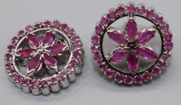 Silver and ruby floral earrings, the round fronts each set with twenty three round and six