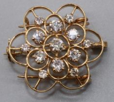 Yellow metal floral diamond brooch, set with twelve brilliant cut diamonds in claw settings, on open