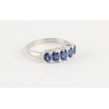 A platinum sapphire five stone ring, the graduated oval cut sapphires weighing approximately 1.57