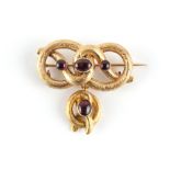 A Victorian unmarked gold cabochon oval garnet knot brooch, 38mm wide excluding pin.