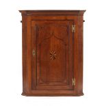 Property of a gentleman - a George III oak & parquetry inlaid corner wall cupboard, enclosing shaped