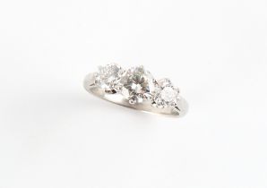 An 18ct white gold diamond three stone ring, the centre round brilliant cut diamond weighing an
