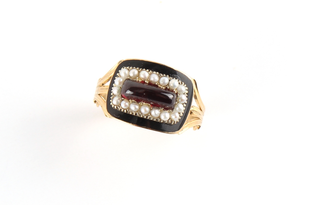 A 19th century gold black enamel & seed pearl mourning ring, set with a cabochon garnet, with bi-