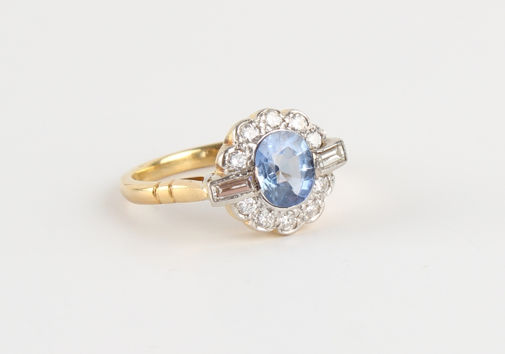 An 18ct yellow gold sapphire & diamond cluster ring, the round cut sapphire weighing an estimated