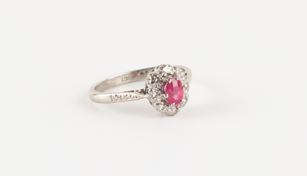 An 18ct white gold ruby & diamond oval cluster ring, size L.