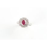 An Art Deco style platinum ruby & diamond ring, the oval cushion cut ruby weighing approximately 0.