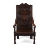 Property of a deceased estate - a 17th century carved oak armchair, with twin panelled back & turned
