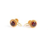 Property of a lady - a pair of 9ct gold earrings set with a single cut red stone, with screw