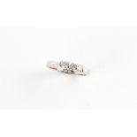 An 18ct white gold diamond three stone ring, the round brilliant cut diamonds weighing a total of