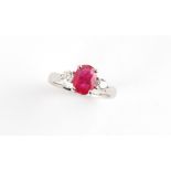A platinum ruby & diamond three stone ring, the oval cushion cut ruby weighing approximately 1.51