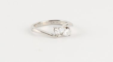 A platinum diamond two stone crossover ring, the two pear shaped diamonds weighing approximately 0.