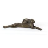 Property of a deceased estate - a bronzed resin model of a reclining hare, 26ins. (66cms.) long.