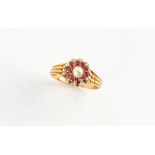 A late 19th / early 20th century ruby diamond & pearl circular flowerhead cluster ring, the