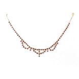 A 9ct gold garnet festoon necklace, the round cut garnets in closed back collets, 14.35ins. (36.