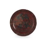An 18th century Chinese cinnabar lacquer charger, extensively damaged, 18ins. (45.7cms.) diameter,