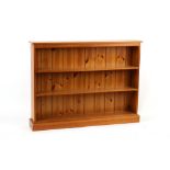 Property of a deceased estate - a modern pine dwarf open bookcase, 54ins. (137cms.) wide (overall).