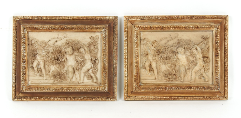 Property of a lady - a pair of reconstituted marble relief plaques depicting cavorting cherubs,