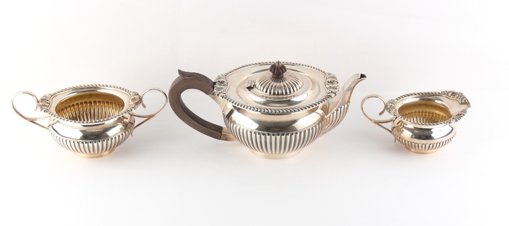 Property of a lady - an early 20th century silver three piece tea set with half fluted decoration