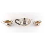 Property of a lady - an early 20th century silver three piece tea set with half fluted decoration