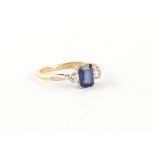 An 18ct yellow gold sapphire & diamond three stone ring, the rectangular cut sapphire weighing