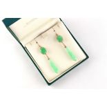 A pair of unmarked yellow gold jadeite pendant earrings, with apple green inclusions, each