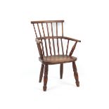 Property of a gentleman - a 19th century child's elm seated comb back elbow chair, with turned legs,