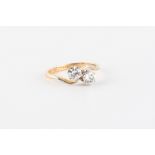 An 18ct yellow gold diamond two stone crossover ring, the round brilliant cut diamonds weighing