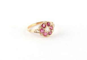 A yellow gold ruby & diamond flowerhead cluster ring, the round cut rubies weighing a total of