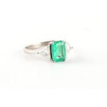 A good unmarked 18ct white gold (tested) emerald & diamond three stone ring, the certificated