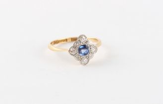 An 18ct yellow gold sapphire & diamond ring, the round cut sapphire set within a border of round cut