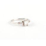 Property of a lady - a platinum emerald cut diamond ring, with baguette diamond shoulders, the