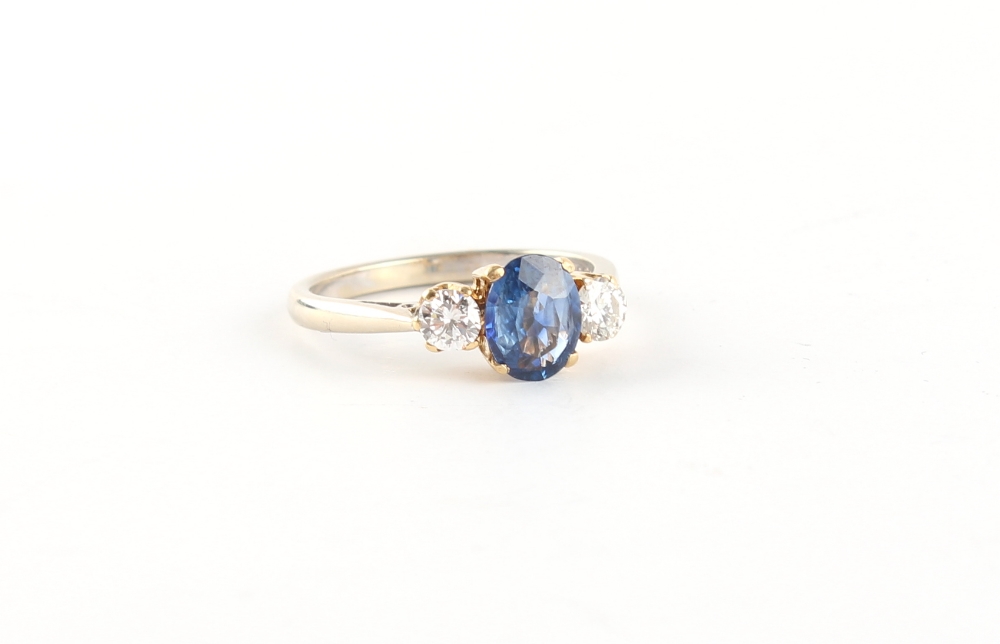 An 18ct white gold sapphire & diamond three stone ring, the oval cushion cut sapphire weighing