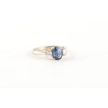 An 18ct white gold sapphire & diamond three stone ring, the oval cushion cut sapphire weighing