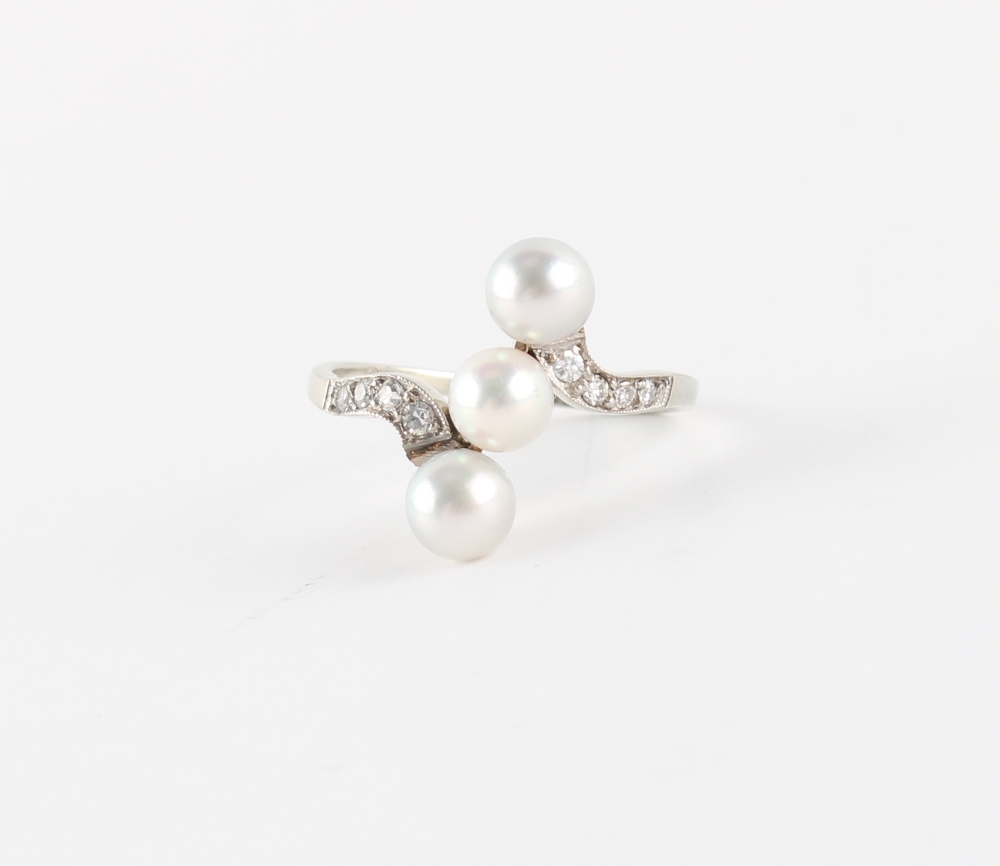 An 18ct white gold pearl & diamond crossover ring, the largest of the three pearls measuring