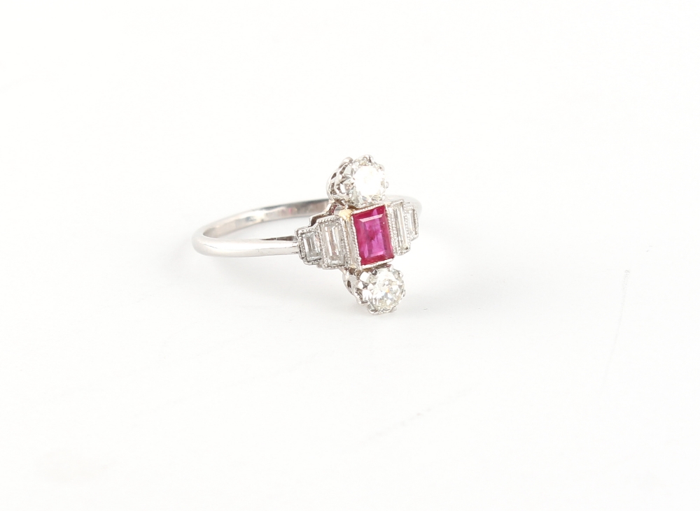 An Art Deco style platinum ruby & diamond ring, the rectangular cut ruby flanked by baguette cut