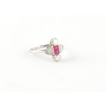 An Art Deco style platinum ruby & diamond ring, the rectangular cut ruby flanked by baguette cut
