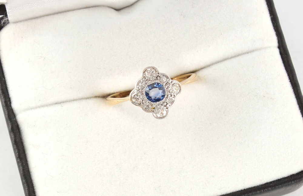 An 18ct yellow gold sapphire & diamond ring, the round cut sapphire set within a border of round cut - Image 2 of 2