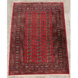 Property of a gentleman - a Turkoman design hand-knotted wool rug with red field, 73 by 50ins. (