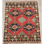 Property of a gentleman - a Caucasian design hand-knotted wool rug with red field, 68 by 55ins. (173