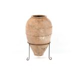 A Turkish terracotta olive or water jar, on stand, 29.75ins. (75.5cms.) high (overall).